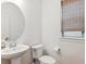 Powder room featuring a modern pedestal sink, neutral paint and window with woven shade at 10360 E 57Th Pl, Denver, CO 80238