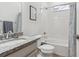 Bright bathroom with granite countertop, white tile surround tub, and framed wall art at 10360 E 57Th Pl, Denver, CO 80238