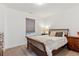 Cozy bedroom featuring a wooden bed frame, neutral carpet, and warm lighting at 10360 E 57Th Pl, Denver, CO 80238