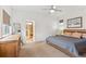 Primary bedroom with large bed, dresser and an en-suite bathroom at 10360 E 57Th Pl, Denver, CO 80238