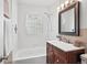 Bright bathroom with white tile, updated vanity, and glass block window at 2751 S Elm St, Denver, CO 80222