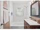 Fresh bathroom featuring white tile, updated vanity, and natural light from glass block window at 2751 S Elm St, Denver, CO 80222