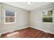 Bright bedroom with wood floors featuring natural light from two windows, creating an inviting atmosphere at 2751 S Elm St, Denver, CO 80222