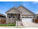 Charming home featuring a well-manicured lawn, white garage door, and inviting front porch at 1056 S Elk Way, Aurora, CO 80018