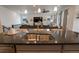 Kitchen island with stainless steel sink, pendant lighting, and view of the living room at 1056 S Elk Way, Aurora, CO 80018