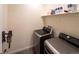 Convenient laundry room featuring modern washer and dryer with extra shelving space for storage at 1056 S Elk Way, Aurora, CO 80018