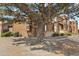Exterior of the townhome with a mature tree in the front yard, brown wood siding, and stone accents at 2569 Devonshire Ct # 72, Denver, CO 80229