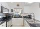 Bright kitchen featuring granite counters, stainless steel appliances, and a cozy window with an aquarium at 2569 Devonshire Ct # 72, Denver, CO 80229