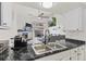Open concept kitchen with granite countertops, stainless steel sink, and view to the living room and fireplace at 2569 Devonshire Ct # 72, Denver, CO 80229