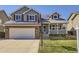 Charming two-story home featuring a brick facade, gray siding, solar panels and a welcoming front porch at 13212 Clermont Cir, Thornton, CO 80241