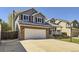 Charming two-story home with a brick facade and gray siding, a well-manicured lawn and solar panels at 13212 Clermont Cir, Thornton, CO 80241