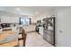 Bright kitchen featuring white cabinets, stainless steel appliances, and a dining table at 13212 Clermont Cir, Thornton, CO 80241