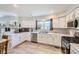 Bright kitchen featuring white cabinets, modern appliances, and a large window at 13212 Clermont Cir, Thornton, CO 80241