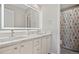 Bright bathroom with a double vanity sink and a large, modern, illuminated mirror at 10058 Glenstone Cir, Highlands Ranch, CO 80130