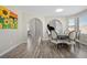 Bright dining room featuring wood floors, a modern table with chairs, and a sunflower painting at 10058 Glenstone Cir, Highlands Ranch, CO 80130