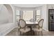 Charming dining area with a bay window, modern table and chairs and stainless steel refrigerator at 10058 Glenstone Cir, Highlands Ranch, CO 80130