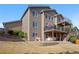 Exterior of a two-story home with a deck, patio, landscaped yard, and mature trees at 10058 Glenstone Cir, Highlands Ranch, CO 80130