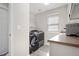 Bright laundry room features a modern washer and dryer set, shelving and a sunny window at 10058 Glenstone Cir, Highlands Ranch, CO 80130