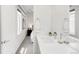 Modern bathroom featuring double sink, and a view to the bedroom with accent wall at 1238 Quitman St # 2, Denver, CO 80204