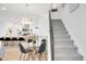 A dining area sits adjacent to an open kitchen with modern light fixtures and a staircase nearby at 1238 Quitman St # 2, Denver, CO 80204