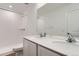 Modern bathroom features a double sink with quartz counters, a large mirror and tiled shower over tub at 3919 N Shawnee St, Aurora, CO 80019