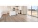Bright kitchen boasts white cabinets, stainless appliances, an island and wood-look flooring at 3919 N Shawnee St, Aurora, CO 80019