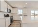 Bright kitchen with stainless steel appliances, quartz countertops, and stylish white cabinetry at 3919 N Shawnee St, Aurora, CO 80019