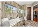 Spa-like bathroom with soaking tub, mosaic tile, and natural light from a large window at 7367 S Tempe Ct, Aurora, CO 80016