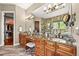 Luxurious bathroom featuring dual vanities with granite countertops and wood cabinets at 7367 S Tempe Ct, Aurora, CO 80016