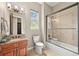 Bathroom with a walk-in glass shower, wood vanity, and a view of the outside at 7367 S Tempe Ct, Aurora, CO 80016