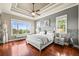 Bright bedroom with hardwood floors, tray ceiling, and large windows for natural light at 7367 S Tempe Ct, Aurora, CO 80016