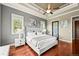 Cozy bedroom with wood floors, fan, tray ceiling and natural light from three windows at 7367 S Tempe Ct, Aurora, CO 80016