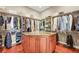 Walk-in closet boasts an island, custom shelving and ample storage space at 7367 S Tempe Ct, Aurora, CO 80016