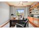 Well-lit home office featuring a large desk, comfortable chair, and view of the outside at 7367 S Tempe Ct, Aurora, CO 80016