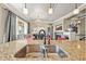 Gourmet kitchen sink with granite countertops and stylish pendants and chandelier at 7367 S Tempe Ct, Aurora, CO 80016