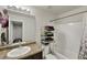 Bright bathroom boasts a single vanity, shower-tub combo, and stacked towels for storage at 47349 Lily Ave, Bennett, CO 80102