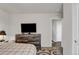 Bedroom with a dresser and TV features an adjoining bathroom at 47349 Lily Ave, Bennett, CO 80102