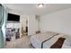Spacious bedroom with a TV, shelves, carpeted floors, and access to the bathroom at 47349 Lily Ave, Bennett, CO 80102