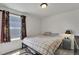 This bedroom features a bed, side table with a lamp, and a window with curtains at 47349 Lily Ave, Bennett, CO 80102