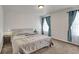 Bright bedroom featuring a bed, side tables, and windows with lovely curtains at 47349 Lily Ave, Bennett, CO 80102