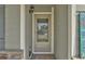 Close-up of the front door featuring a storm door, sidelights, and stylish hardware for a warm and welcoming entrance at 47349 Lily Ave, Bennett, CO 80102