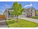 Inviting two-story home featuring a covered porch, well-kept lawn, and a two-car attached garage with a concrete driveway at 47349 Lily Ave, Bennett, CO 80102