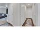 Bright hallway with multiple doors, carpeted floors on one side and wood floors with a rug on the other at 47349 Lily Ave, Bennett, CO 80102