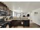 Well-equipped kitchen with dark cabinets, modern appliances, and a breakfast bar overlooking the living room at 47349 Lily Ave, Bennett, CO 80102