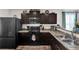 Modern kitchen with dark cabinets, stainless steel appliances, and a breakfast bar, perfect for cooking and entertaining at 47349 Lily Ave, Bennett, CO 80102