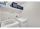 Laundry room features a washer and dryer, and shelving above for storage at 47349 Lily Ave, Bennett, CO 80102