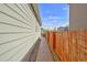 Exterior shot of a walkway between the house and a wooden fence, creating private outdoor access at 47349 Lily Ave, Bennett, CO 80102