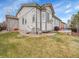 Back exterior of home with grass and patio areas at 10770 Hillrose St, Parker, CO 80134