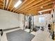 Spacious unfinished basement with exposed beams and workout equipment at 10770 Hillrose St, Parker, CO 80134