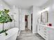 Bright bathroom features a soaking tub, a walk-in shower, and a vanity with double sinks at 10770 Hillrose St, Parker, CO 80134